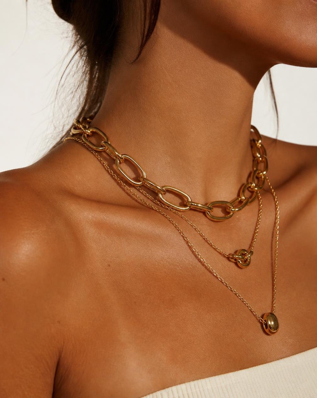 Woman wearing layered gold chain necklaces