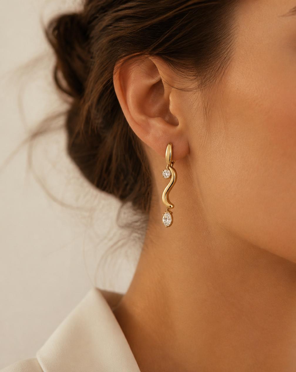 Close-up of a sculptural gold and diamond drop earring