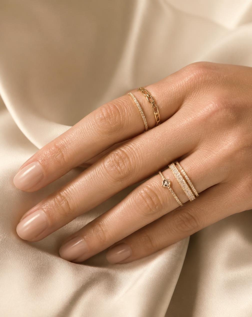 Stacked gold and diamond rings on a woman's hand